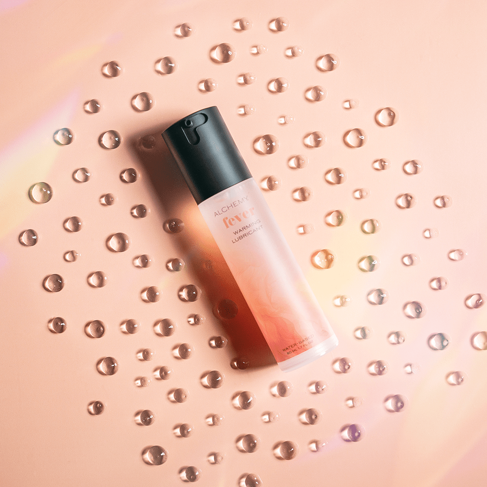 Alchemy Fever: Water-Based Warming Personal Lubricant bottle with liquid droplets
