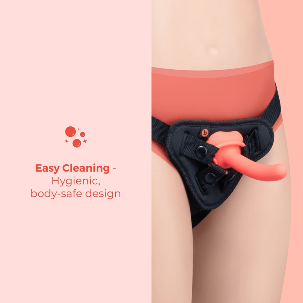 B-Vibe Beginners Strap-On Harness Set with 5-Inch Silicone Dildo Peg on a pink background with text about the hygienic, body-safe design with easy cleaning