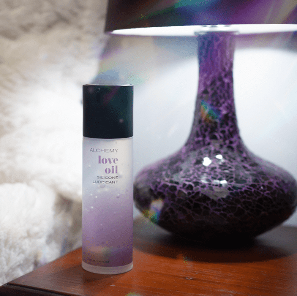 Alchemy Love Oil: Silicone-Based Personal Lubricant bottle on nightstand