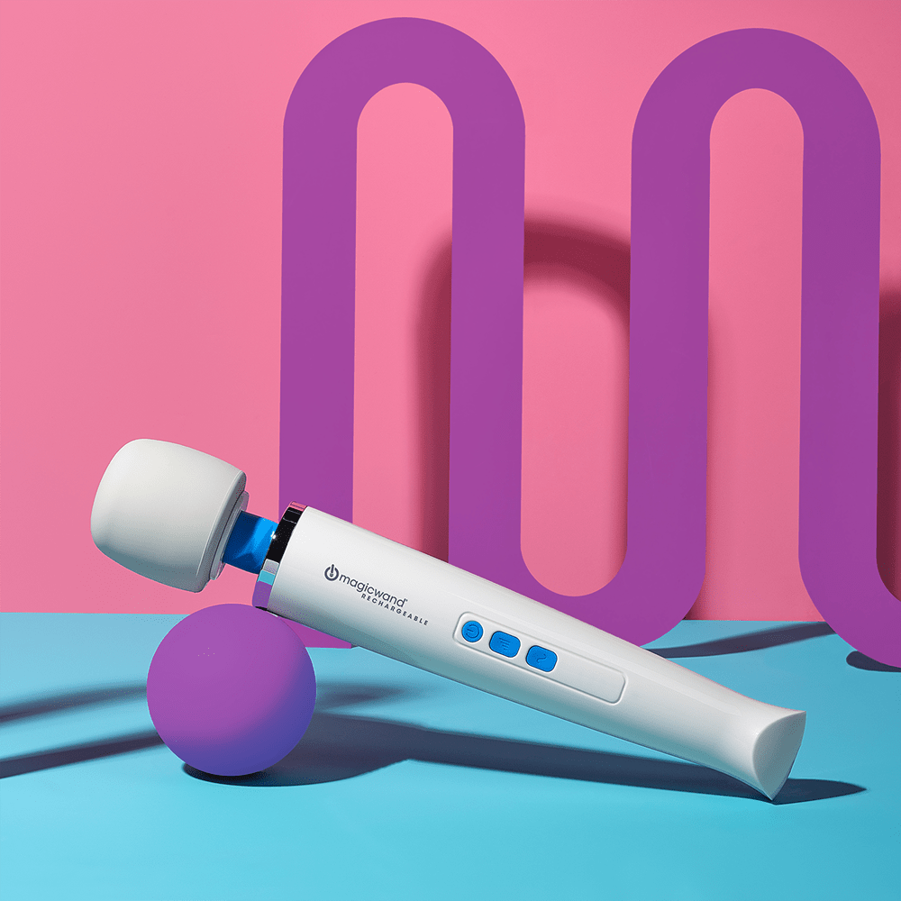 Hitachi Magic Wand Rechargeable HV-270 wand massager in a purple, pink, and turquoise 3D rendering environment with geometric shapes and overhead lighting