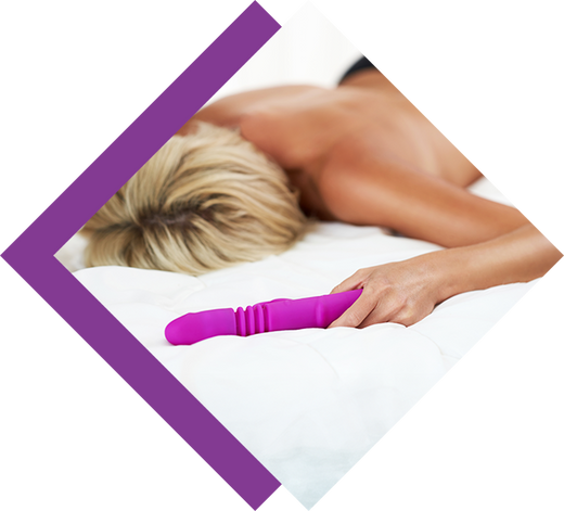 A woman lying on the bed and holding a purple dildo