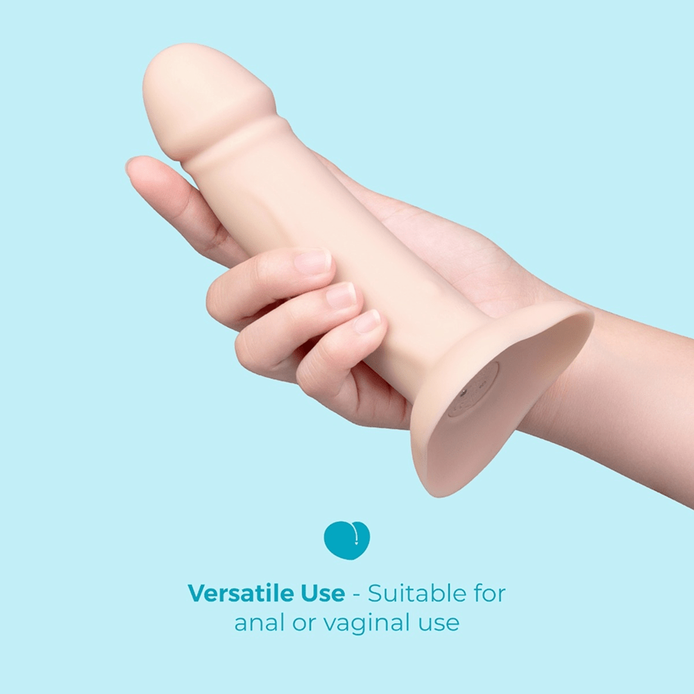 Hand holding beige silicone B-Vibe Every Body Vibrating Strap-On Dildo with text that reads "Versatile use: suitable for anal or vaginal use"