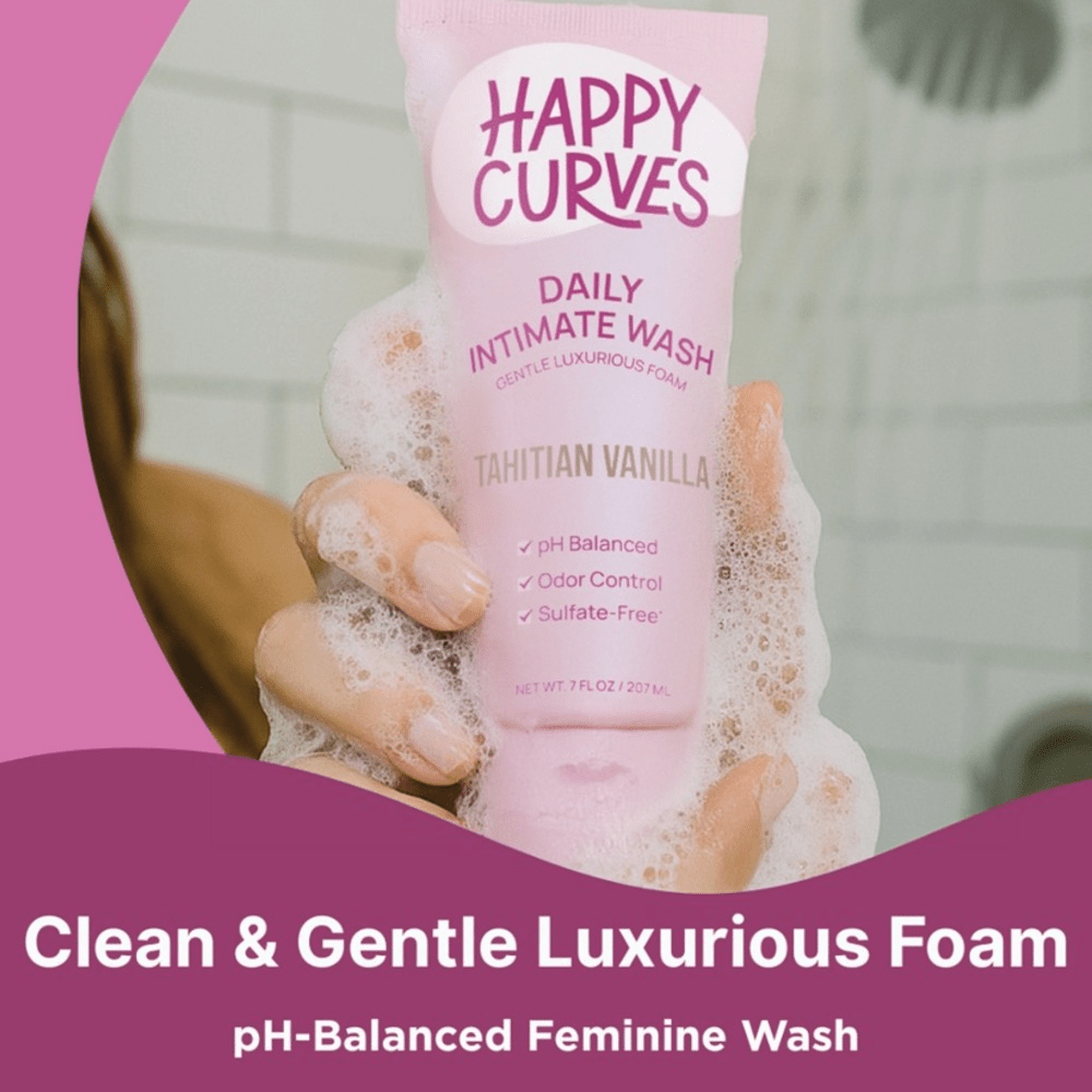 Happy Curves Daily Intimate Wash bottle with foam and pink packaging on a pink background: "clean and gentle luxurious foam: pH-balanced feminine wash"