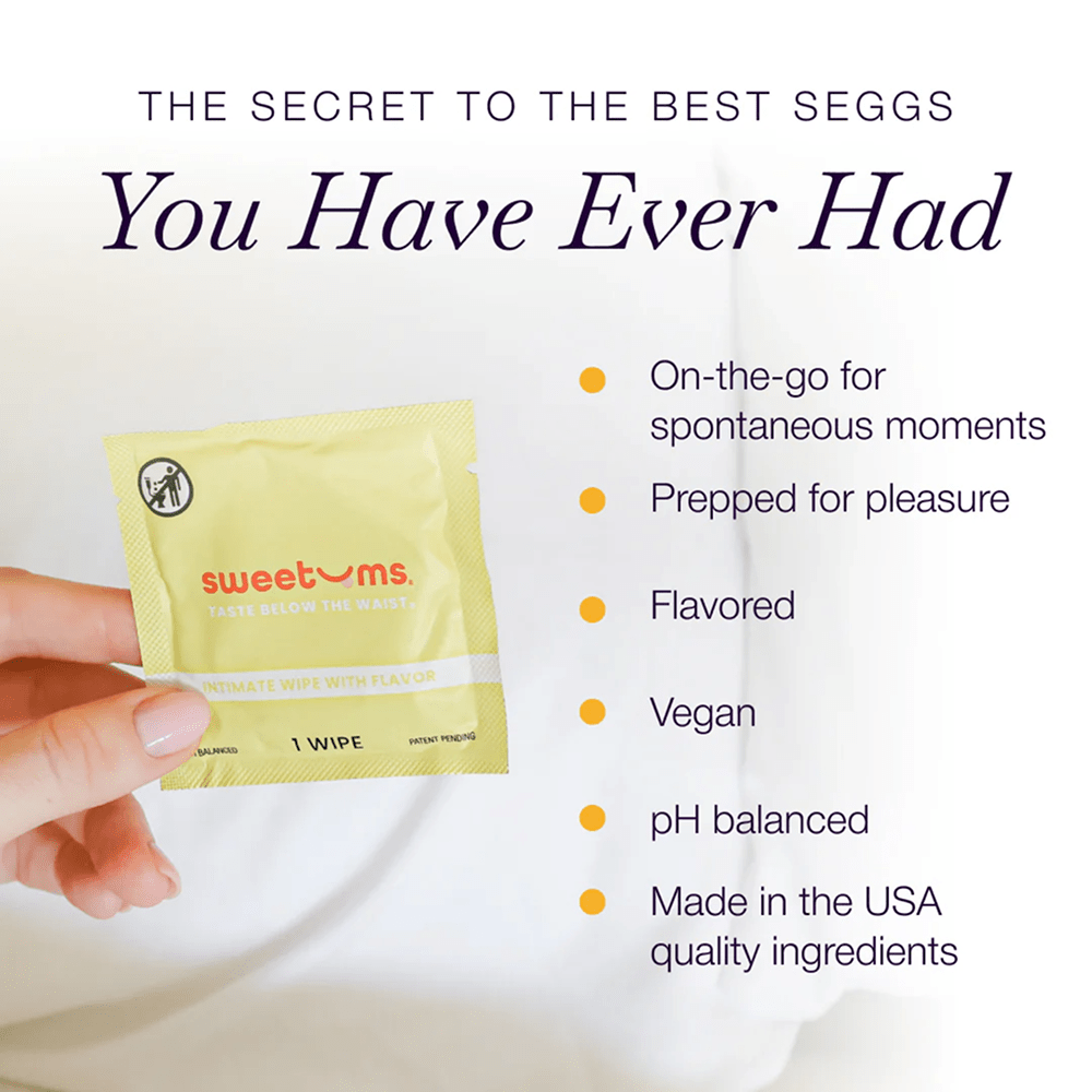Hand holding a yellow Sweetums intimate wipe packet with product features listed on a white background: "on-the-go for spontaneous moments; prepped for pleasure; flavored; vegan; pH balanced; made in the USA with quality ingredients"