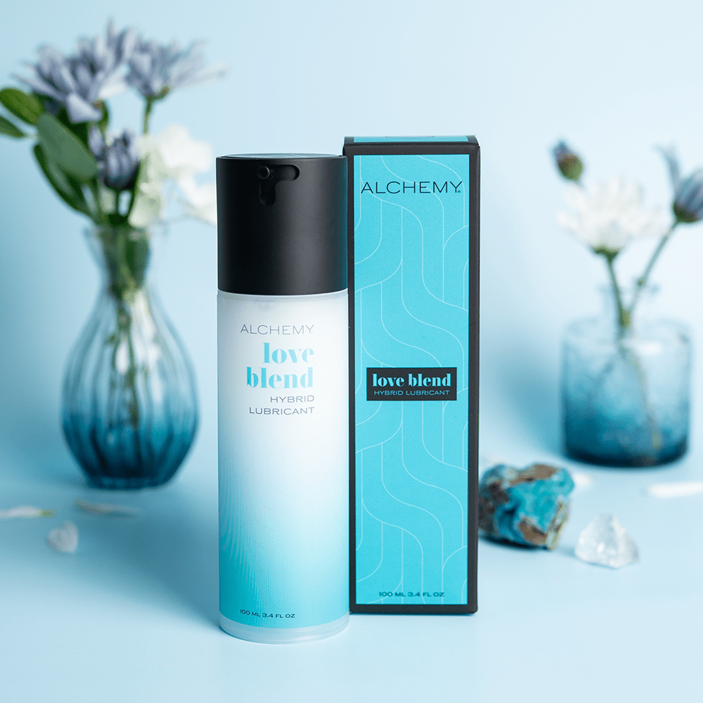 Alchemy Love Blend: Hybrid Personal Lubricant with box on blue background with crystals and flowers