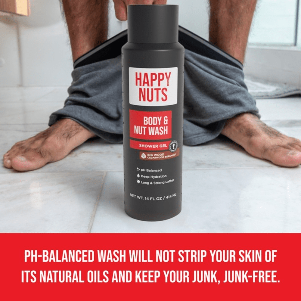 Bottle of Happy Nuts Body & Nut Wash with a person wearing gray pants in the background. "pH-balanced wash will not strip your skin of its natural oils and keepy your junk, junk-free"