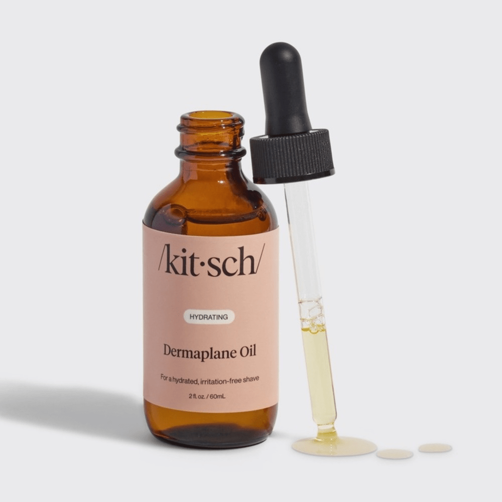 Brown bottle with dropper of Kitsch Dermaplane Shave Oil on a light gray background