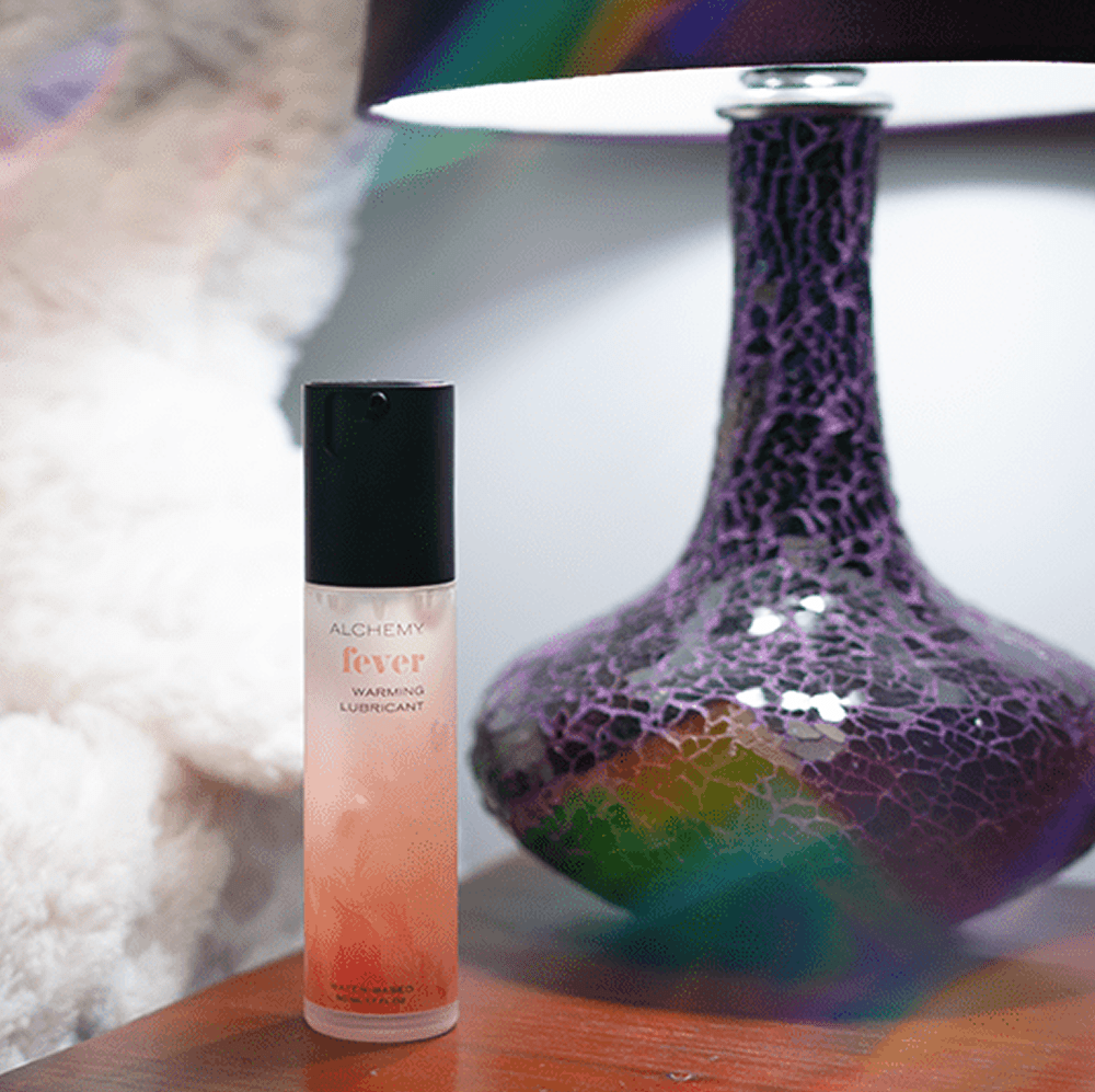 Alchemy Fever: Water-Based Warming Personal Lubricant bottle on nightstand