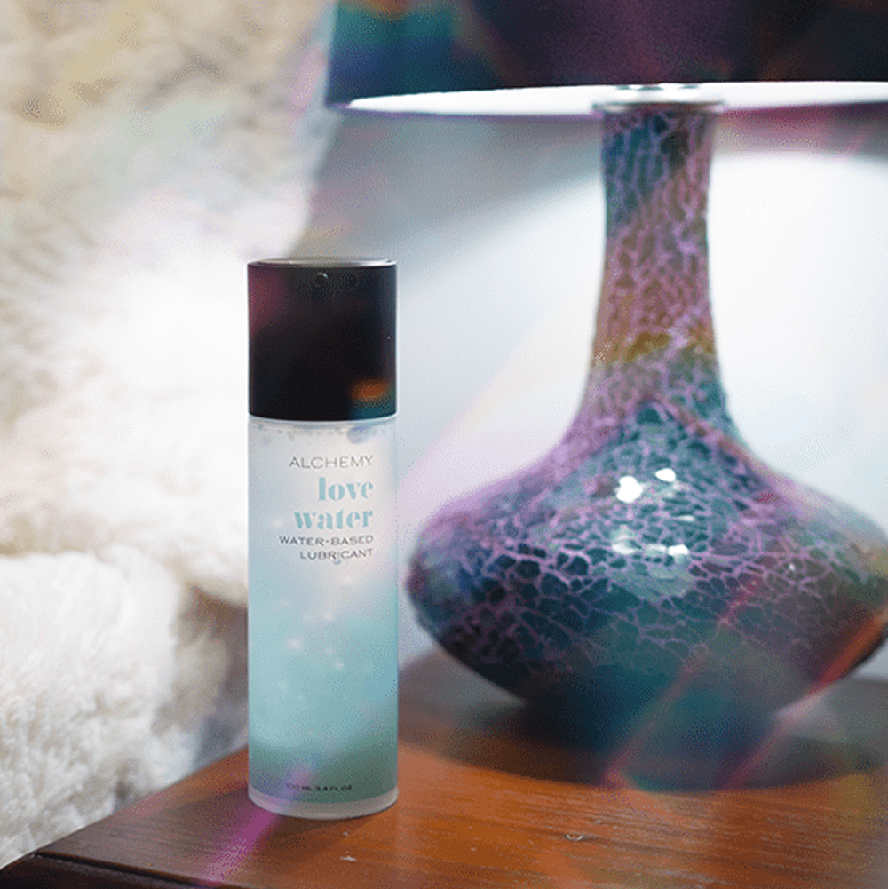 Alchemy Love Water: Water-Based Personal Lubricant bottle on nightstand
