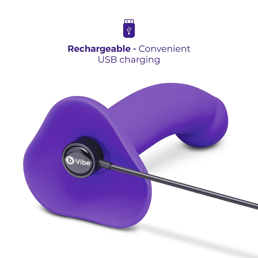 B-Vibe Vibrating Curved Strap-On Dildo with magnetic USB charging cable on white background