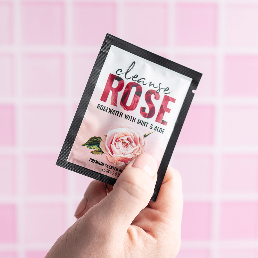 Alchemy Cleanse Rosewater Scented Wipes packet in woman's hand