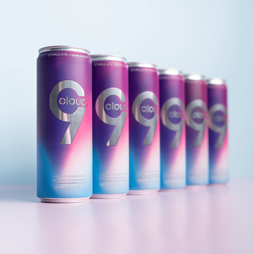 Row of 6 Cloud 9 Aphrodisiac Drink cans with soft studio lighting and a light purple background