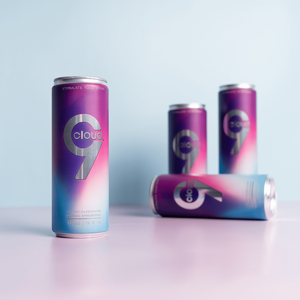 Four Cloud 9 Aphrodisiac Drink cans with soft studio lighting and a light purple background