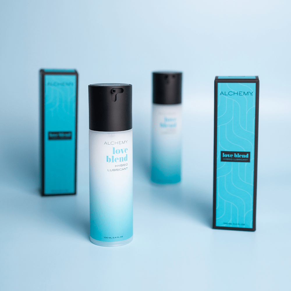 Alchemy Love Blend Hybrid Personal Lubricant bottles and boxes on blue background