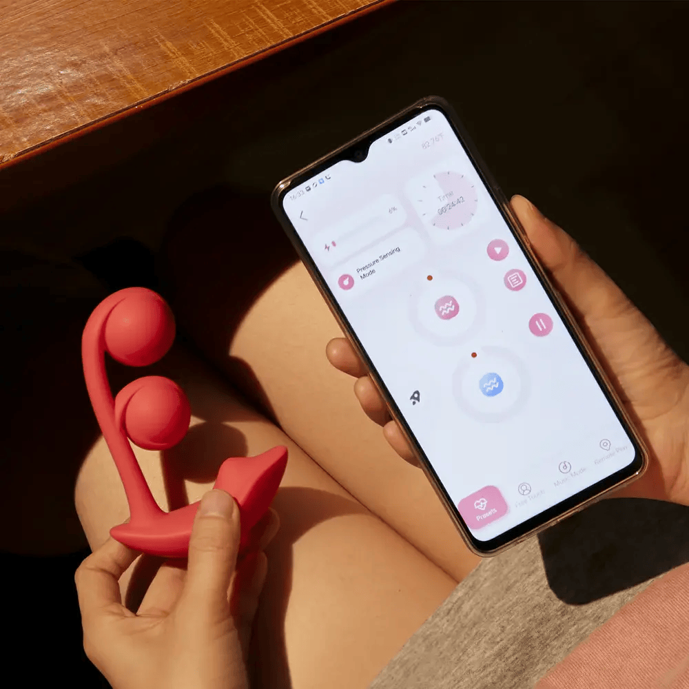 Honey Play Box Melody App-Controlled Kegel Ball Vibrator  – woman holding vibrator in one hand and phone with app screen in the other hand