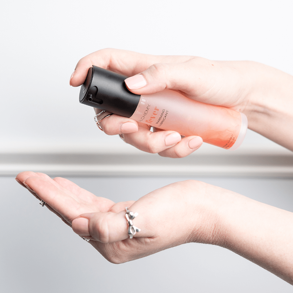 Alchemy Fever: Water-Based Warming Personal Lubricant bottle in woman's hand