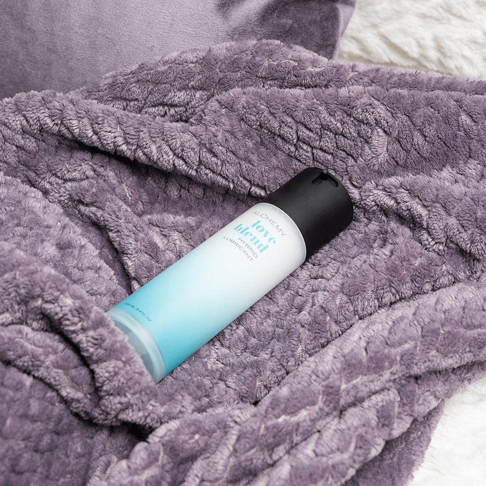 Alchemy Love Blend: Hybrid Personal Lubricant bottle on bed blanket