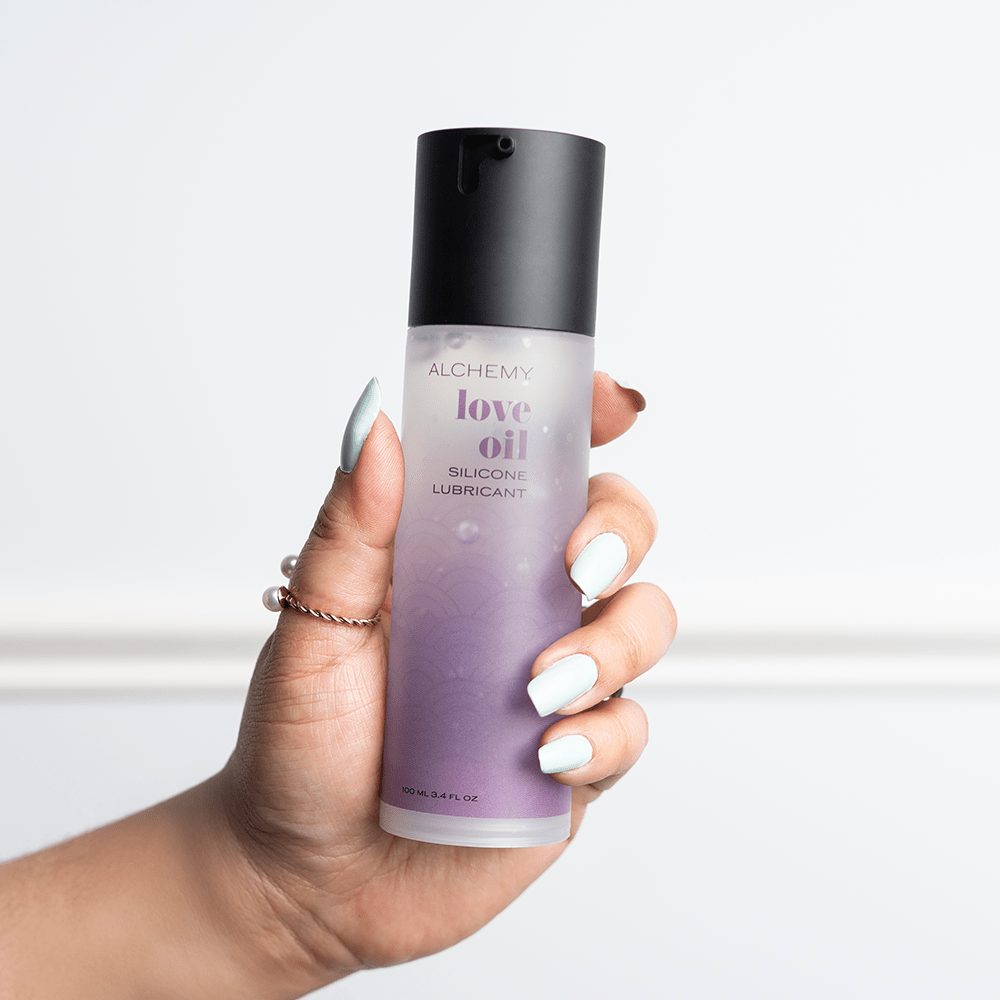 Alchemy Love Oil: Silicone-Based Personal Lubricant bottle in woman's hand