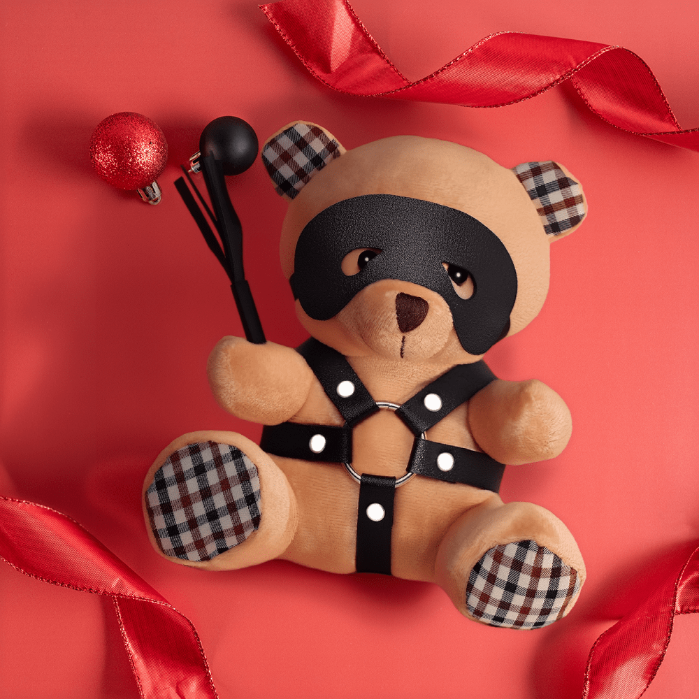 BDSM Keyhain Bear: top view of product on a red background with red ribbons and black and red holiday ornaments