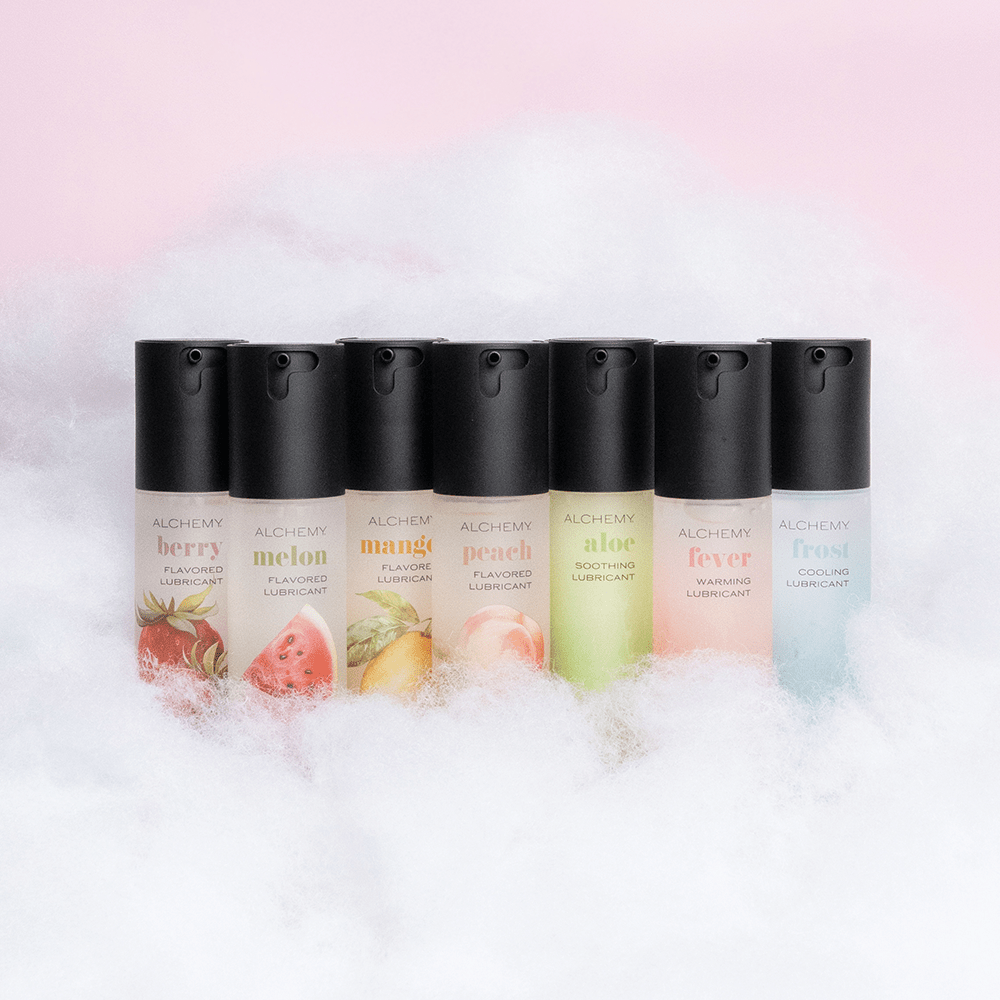 Amazing Intimate Essentials Alchemy Discovery Kit: Alchemy personal lubricant bottles on a fluffy cloud texture against a pink background