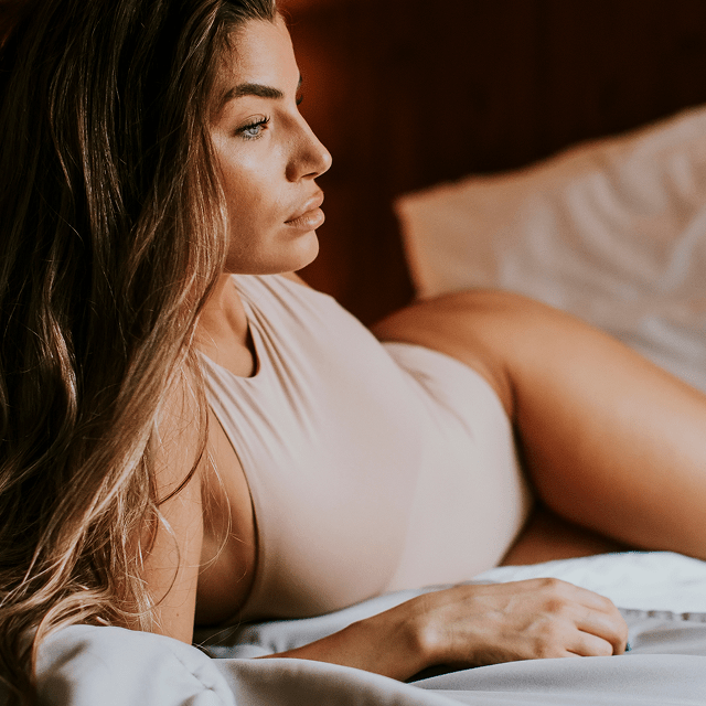 Woman lying on a bed with a warm, soft light