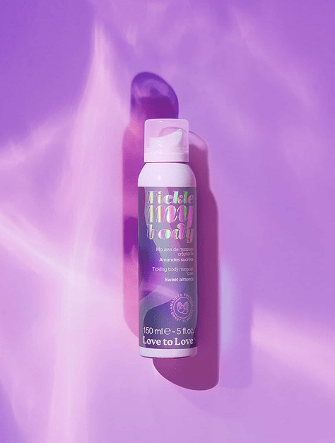 Love to Love Cosmetics Tickle My Body massage foam bottle on a purple background with shimmery lighting