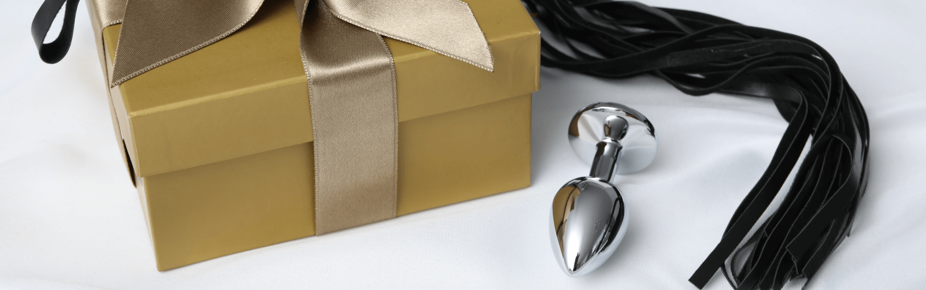 An anal plug, flogger, and gift box
