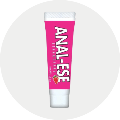 A tube of Anal-Ese Strawberry analgesic cream, featuring a bright pink label with bold white text and a small strawberry graphic, set against a light gray circular background