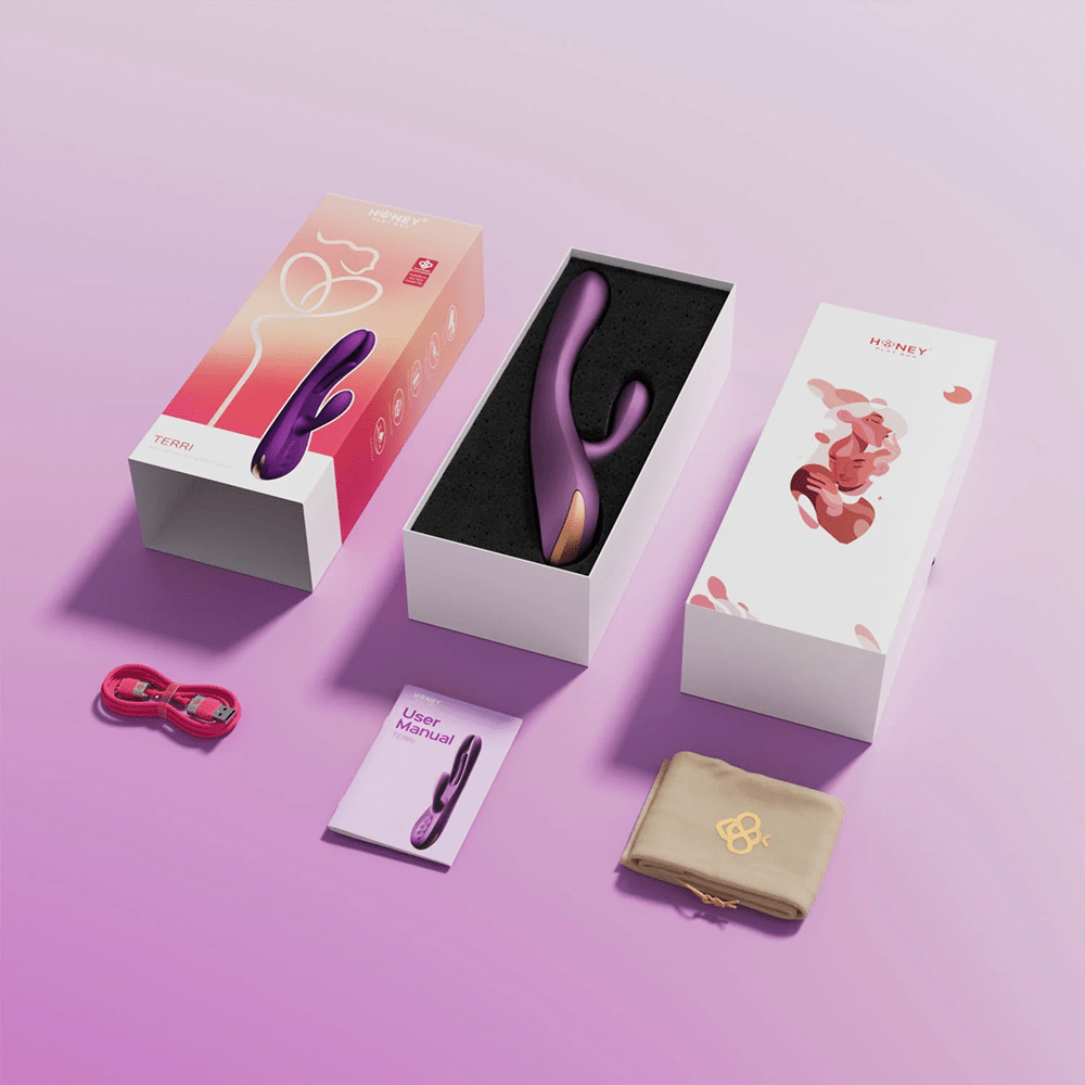Honey Play Box Terri App-Controlled Tapping Rabbit Vibrator: studio photo of the product in its box with all included accessories on a light purple background