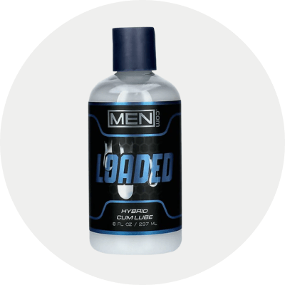 A bottle of MEN.com Loaded Hybrid Cum Lube, featuring a black label with blue and white text and a dark blue cap, set against a light gray circular background