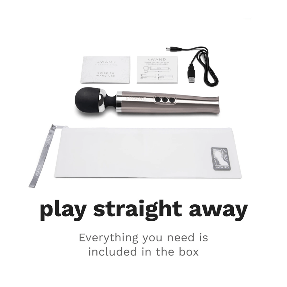 Photo of Le Wand Diecast Luxury Wand Massager on a white background with dark gray text and included accessories: "Play Straight Away: everything you need is included in the box"