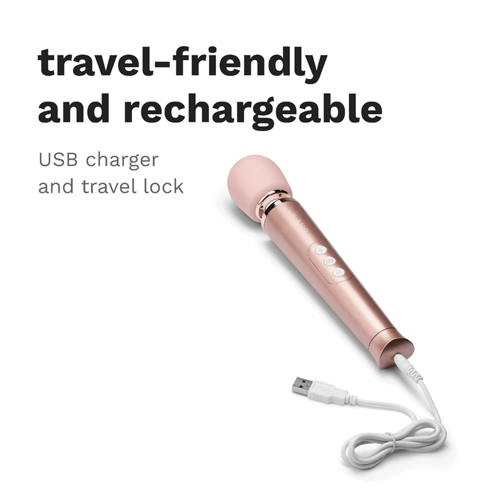 Photo of rose gold Le Wand Petite Luxury Wand Massager on a white background with dark gray text and USB cord: "Travel-Friendly and Rechargeable: USB charger and travel lock"