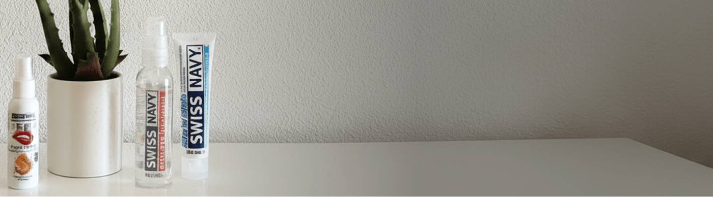 Three Swiss Navy products on a white textured surface with a minimal background and a houseplant