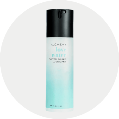 A bottle of Alchemy Love Water Water-Based Lubricant with a black cap and a white-to-light-blue gradient bottle, centered on a light gray circular background