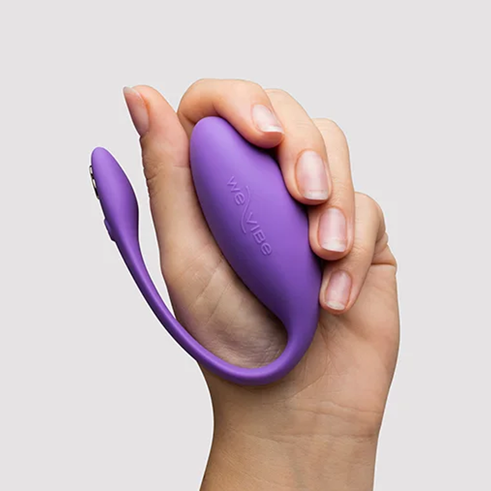Woman's hand holding We-Vibe Jive Lite discreet wearable G-spot vibrator with a light gray background and even studio lighting